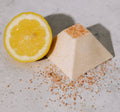 Pyramidal salt soap with lemon on a textured surface